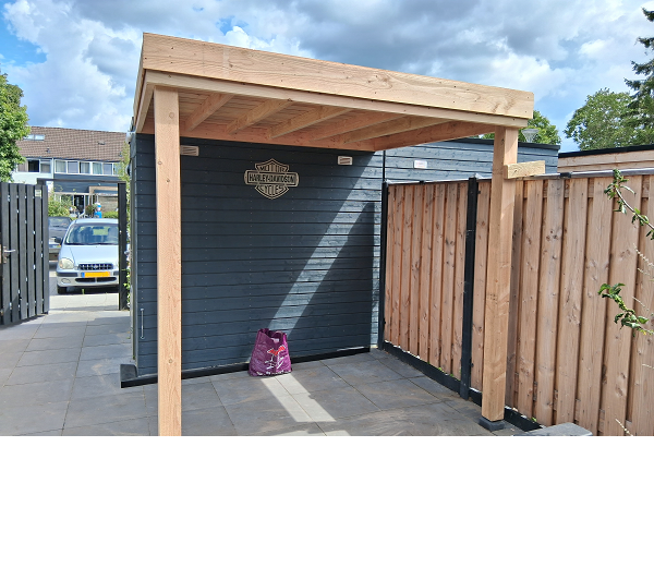 grijze houten berging met aan de voorzijde en afdak van douglas