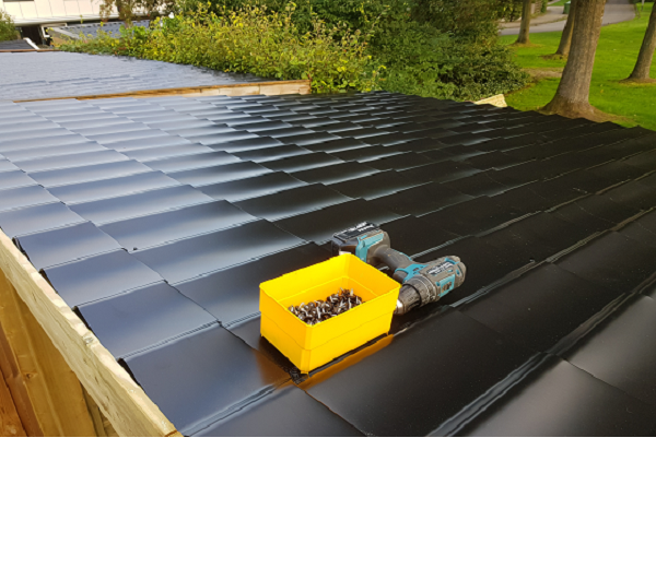 Zwarte dakpanprofielplaten met accuboormachine en schroeven